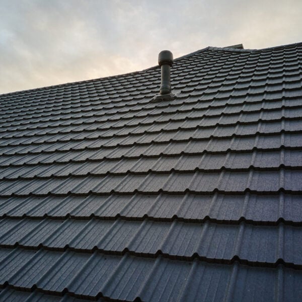Closeup of house roof top covered with metallic shingles.Tiled covering of building.